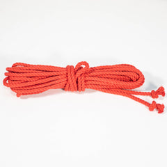 A coiled red cotton rope with a knot at one end, displayed on a white background.