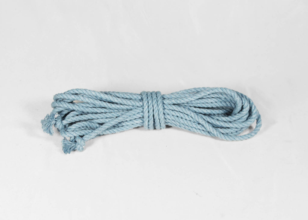 A coiled light blue cotton rope with frayed ends, photographed on a plain white background.